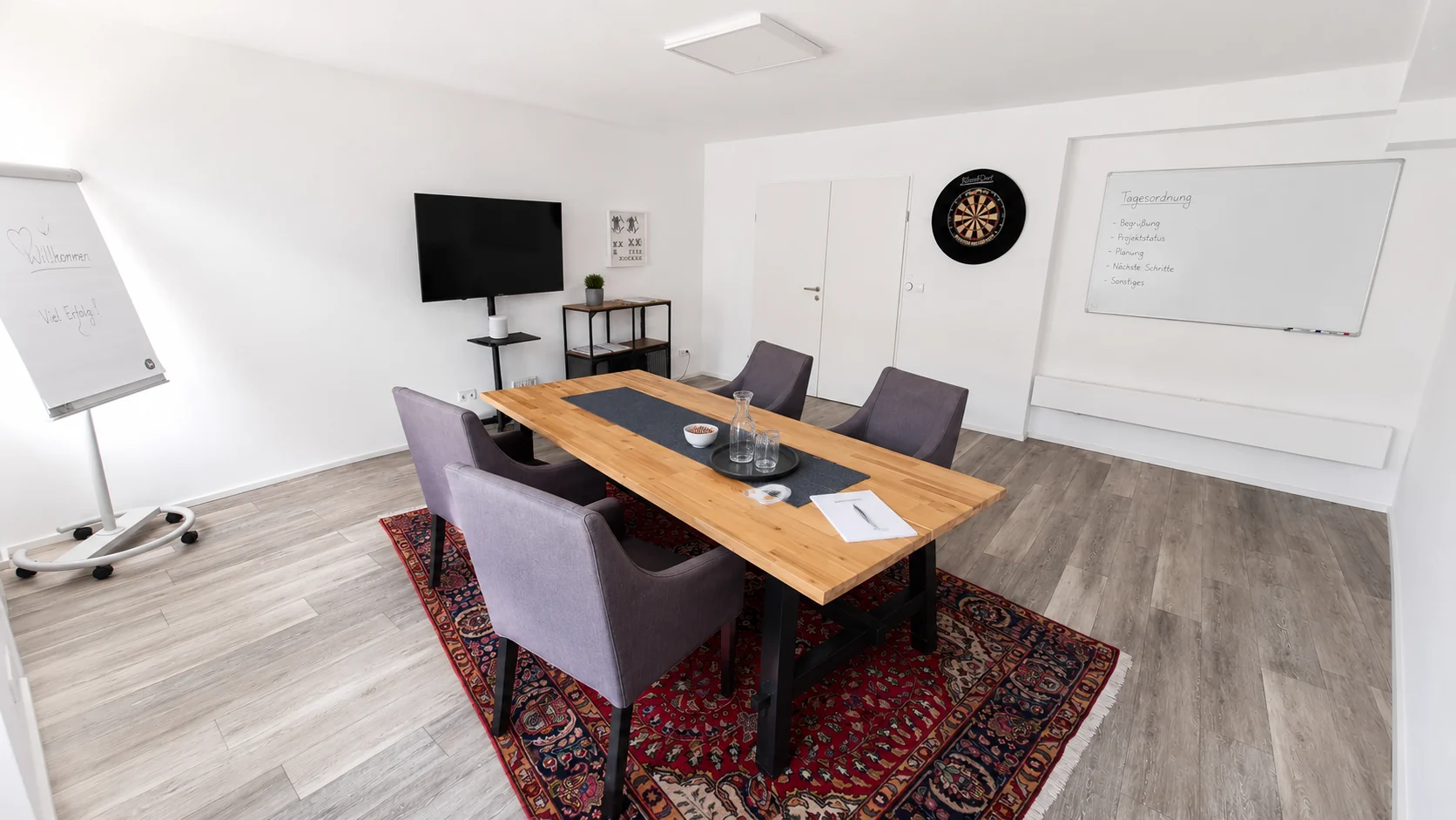 Professioneller Konferenzraum mit Holztisch, Präsentationsbildschirm und Whiteboard für Meetings, Workshops und Kundentermine im K7 Workspace Königstein